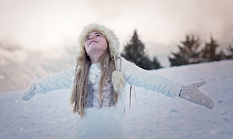 Happy Girl in Snowy Winter Landscape with Fur Hat