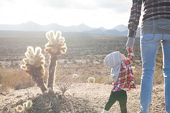 Father and child holding hands in desert landscape