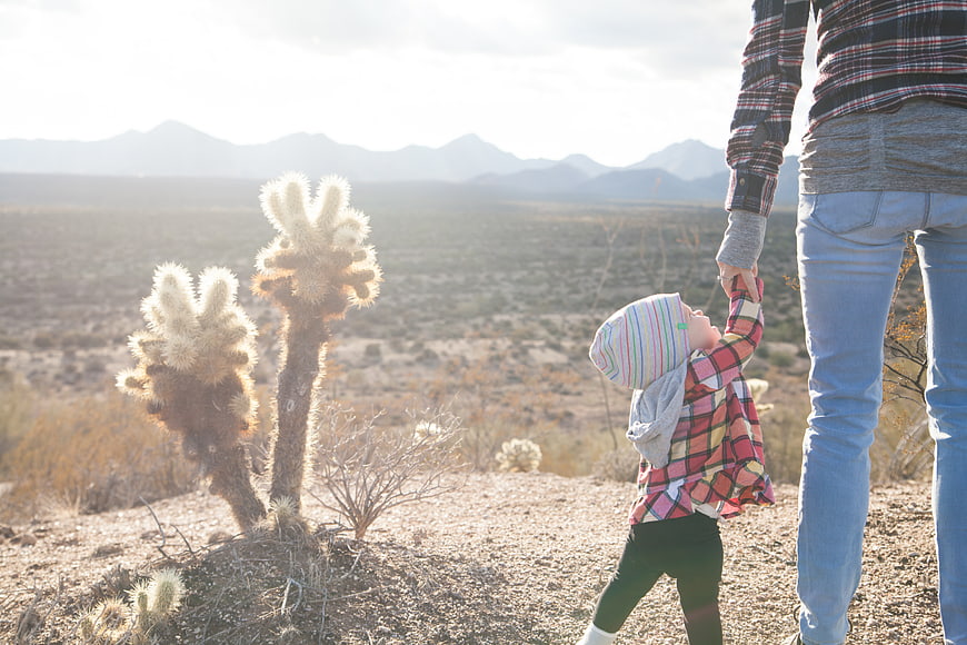 Father and child holding hands in desert landscape