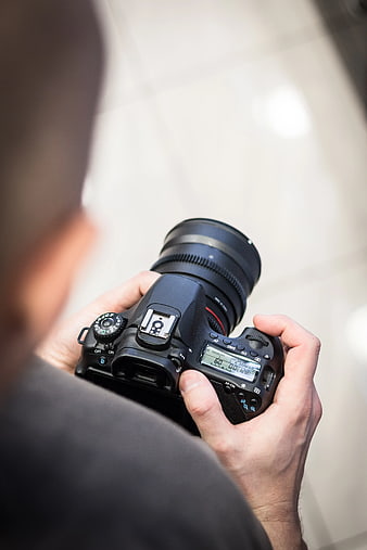 Over-the-shoulder view of photographer holding DSLR camera