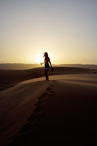 Woman Silhouette on Sand Dune at Sunset