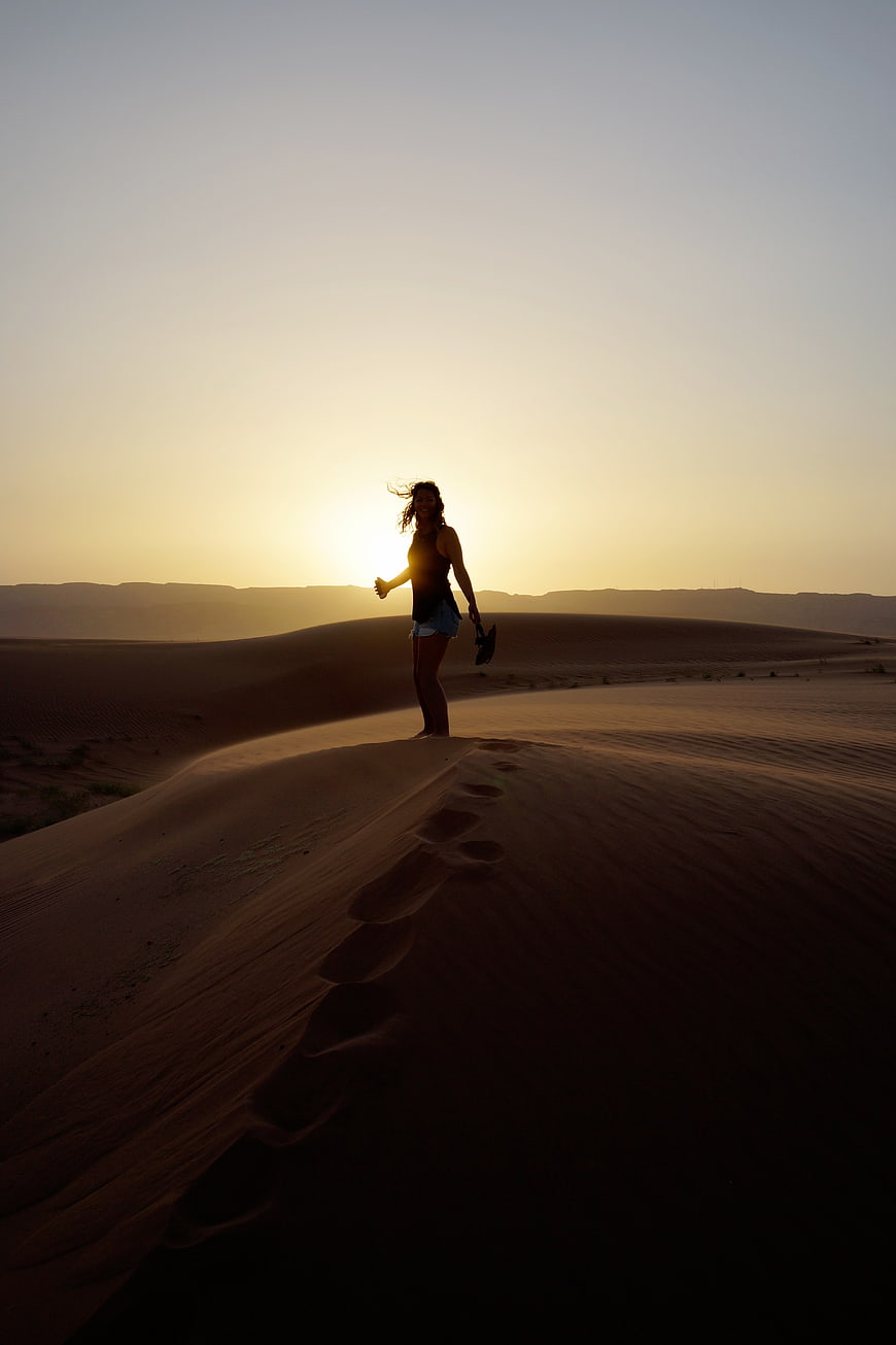 Woman Silhouette on Sand Dune at Sunset