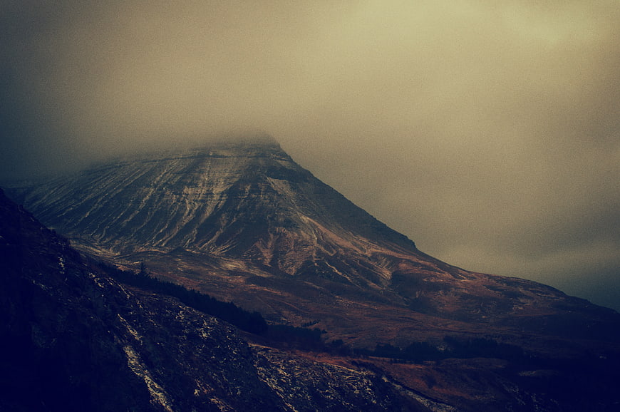 Misty Mountain Peak with Dramatic Clouds and Dark Foreground