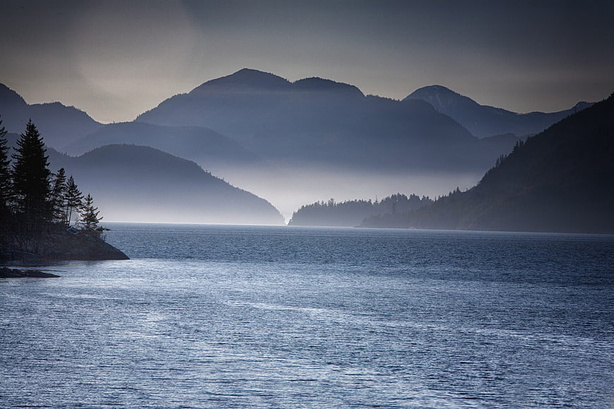 Misty Mountain Lake Landscape with Pine Trees and Calm Water