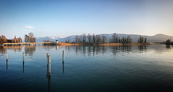 Serene Lake Landscape with Wooden Pier and Mountain Reflections