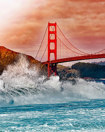 Golden Gate Bridge with dramatic crashing waves and sunset sky