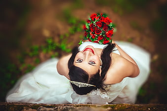 Bride Lying on Ground Holding Red Rose Bouquet