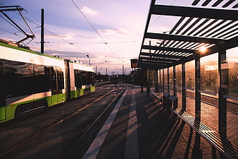 Modern Green Tram at Station During Golden Hour Sunset