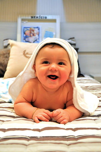 Happy Baby Smiling On Bed With White Towel