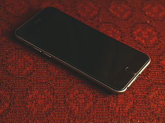 Space Gray Smartphone on Red Textured Fabric Background