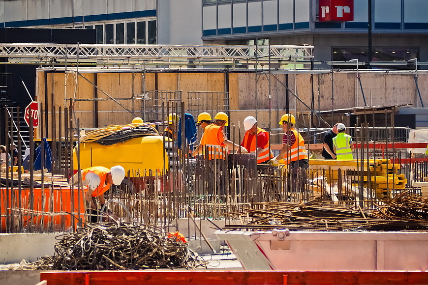 Construction workers building concrete foundation with rebar
