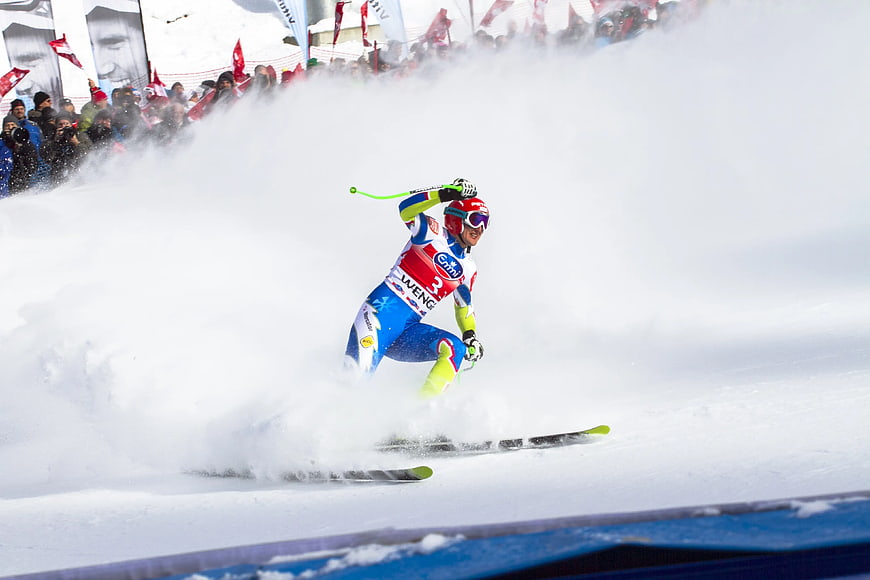 Alpine skier carving turn in powder snow