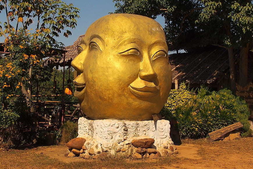 Golden Four-Faced Buddha Sculpture in Garden