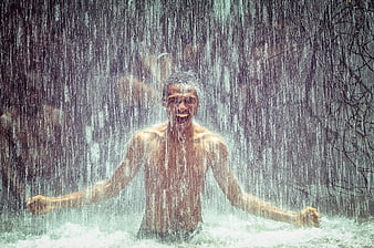 Happy Man Enjoying Heavy Rainfall Outdoors
