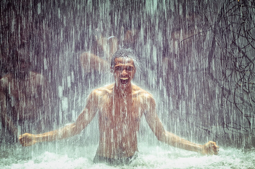 Happy Man Enjoying Heavy Rainfall Outdoors