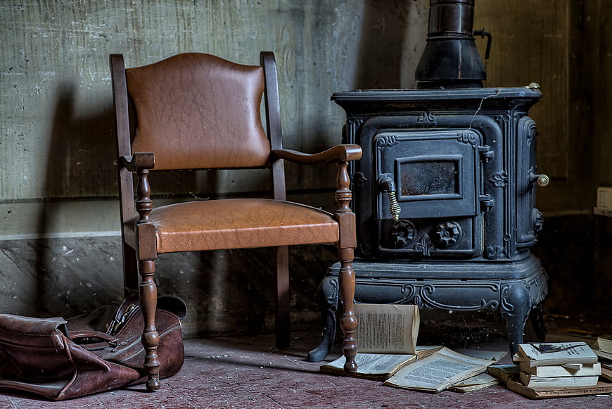 Vintage leather chair and antique wood stove in rustic room