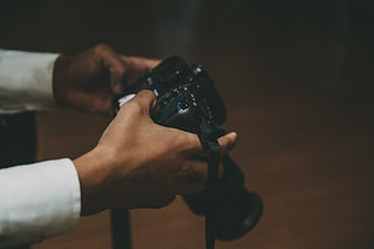 Close-up of hands holding a professional DSLR camera