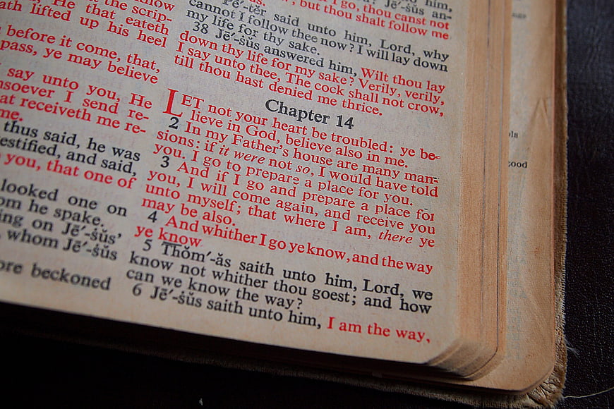 Close-up of Open Bible Page with Red and Black Text