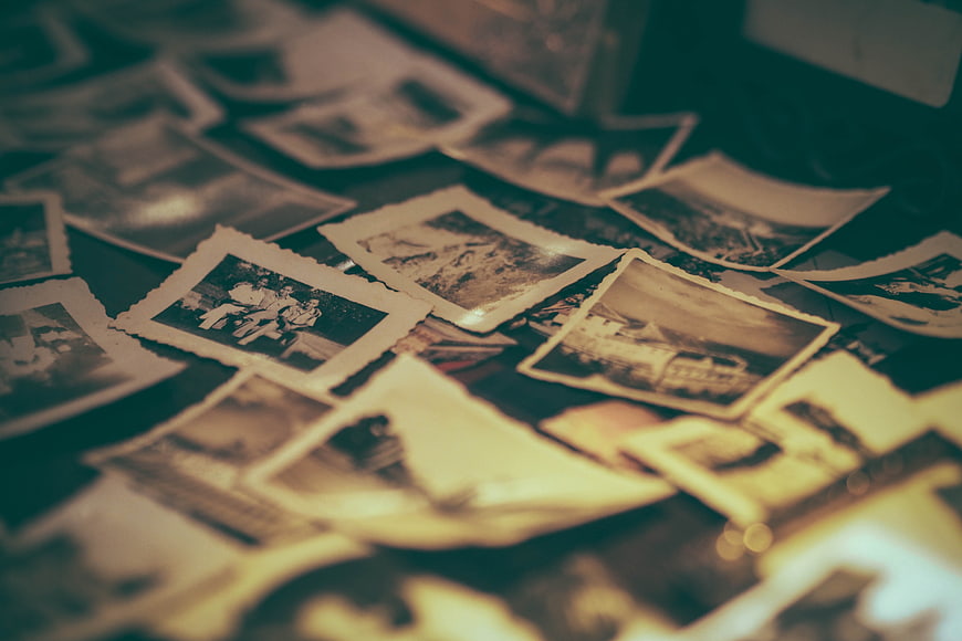 Scattered vintage photographs on a table with shallow depth of field
