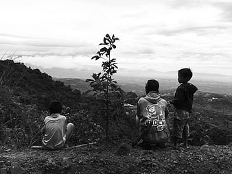 Black and white photo of three children looking at mountain view