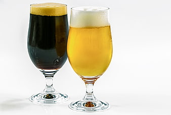 Two glasses of dark stout and golden lager beer on white background