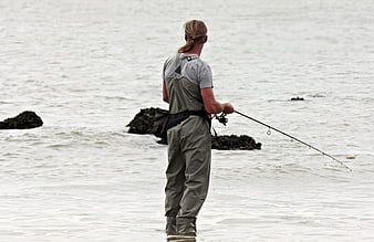 Man Fishing in Waders on Overcast Coast