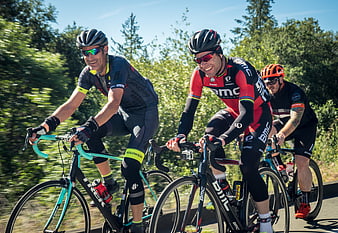 Three male cyclists riding road bikes on a sunny day