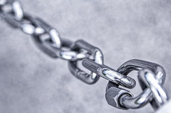 Close-up of heavy metal chain links on gray background