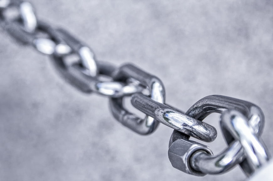 Close-up of heavy metal chain links on gray background