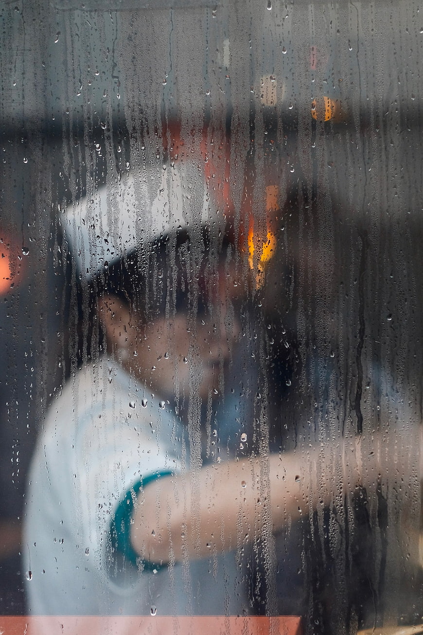 Blurred Chef Cooking Behind Rainy Window
