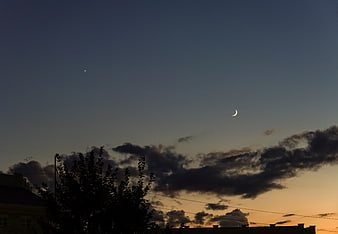Crescent Moon and Star at Dusk Over Silhouetted Trees