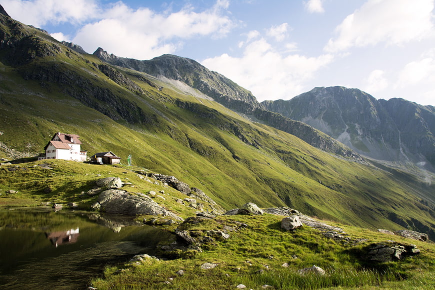 Alpine mountain hut reflected in a serene lake