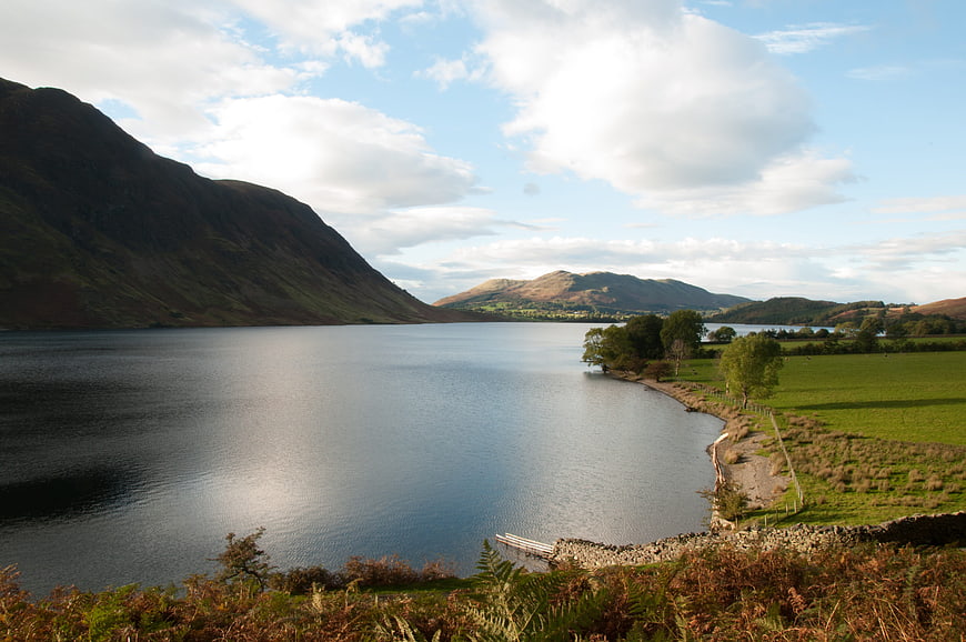 Serene Lake Landscape with Mountains and Green Pastures