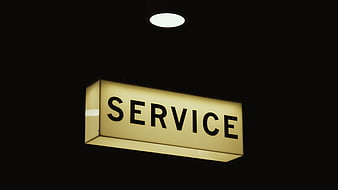 Illuminated Service Sign Hanging in Dark Interior
