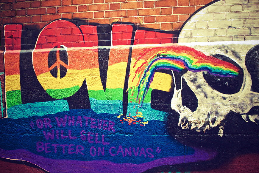 Colorful Graffiti Art with Skull and Rainbow on Brick Wall