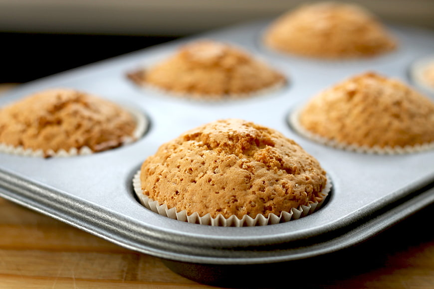 Freshly Baked Muffins In Metal Baking Pan On Wooden Surface