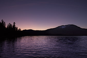 Serene Lake at Dusk with Mountain Silhouette and Purple Sky