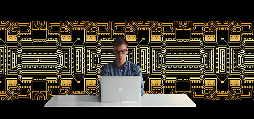 Young man working on laptop with circuit board background