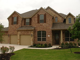 Suburban Brick Home Exterior With Landscaped Lawn And Garage