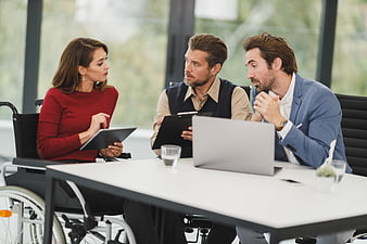 Diverse business team meeting with woman in wheelchair