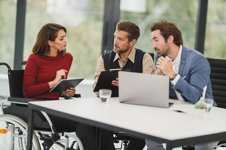 Diverse business team meeting with woman in wheelchair