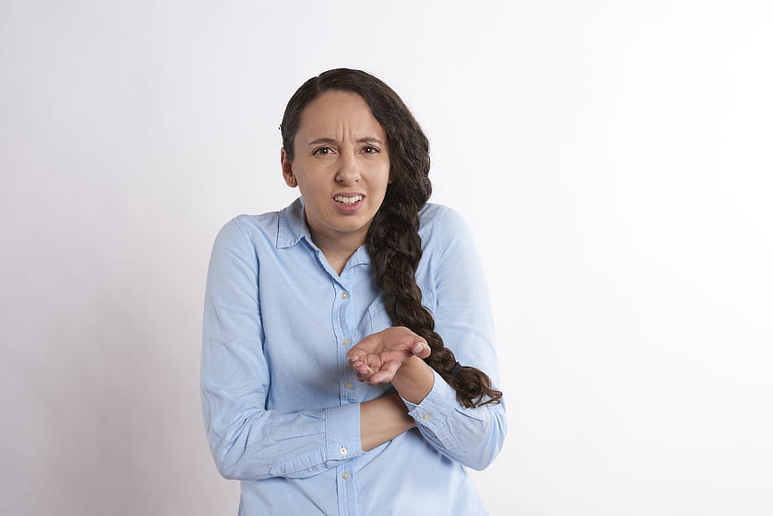 Frustrated young businesswoman with long braid in blue shirt