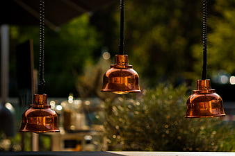 Three Hanging Copper Pendant Lights with Bokeh Background