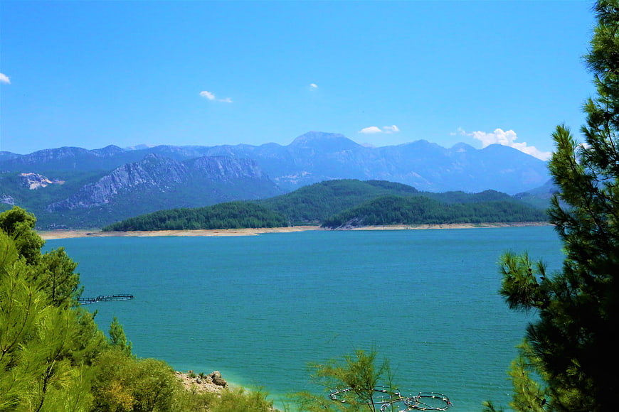 Scenic turquoise lake surrounded by pine forest and mountains