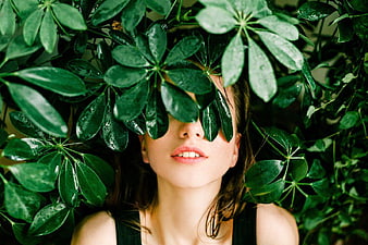 Woman Hiding Behind Green Leaves