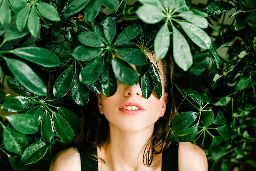 Woman Hiding Behind Green Leaves