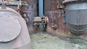 Rusty industrial tanks and machinery in abandoned factory