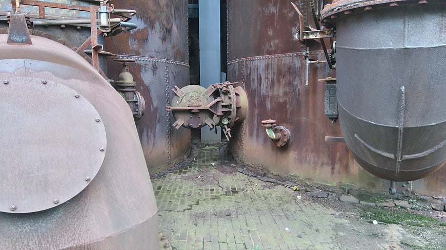 Rusty industrial tanks and machinery in abandoned factory