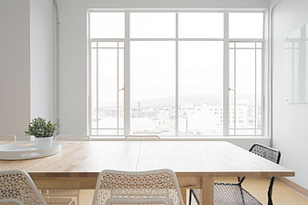 Bright minimalist dining room with large window and city view