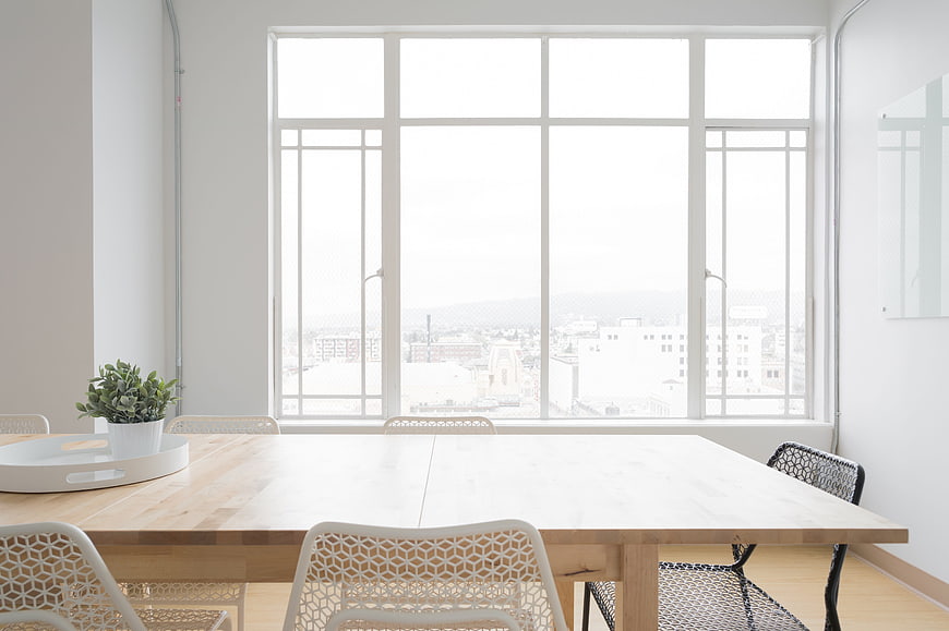 Bright minimalist dining room with large window and city view